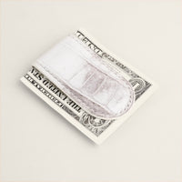 Himalayan crocodile money clip holding folded notes