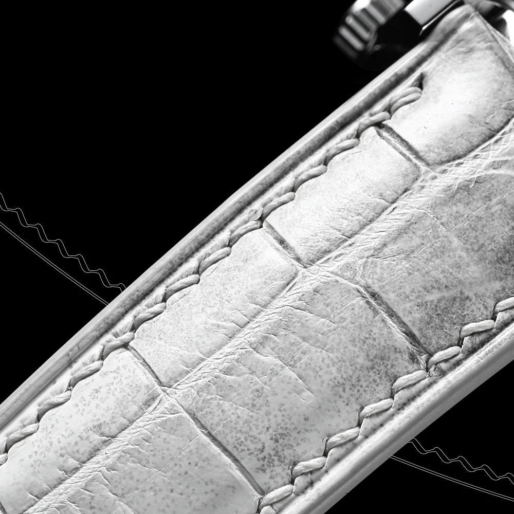 Macro of hand saddle-stitching on pale crocodile leather